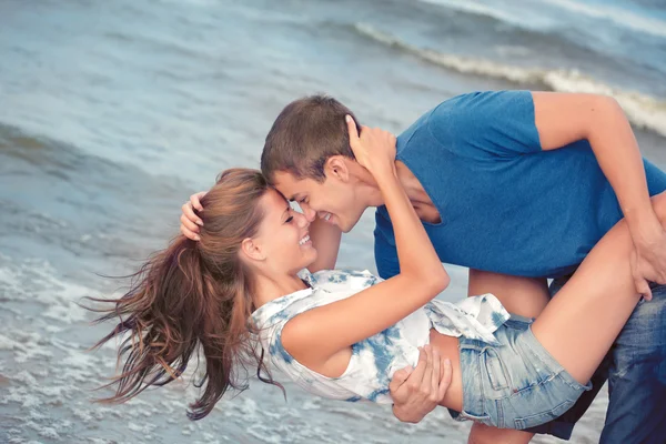 Pár mladých milenců na pláži s Seznamka — Stock fotografie