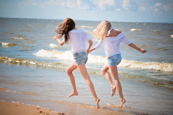 Two yaoung women running on the beach — Stock Photo, Image