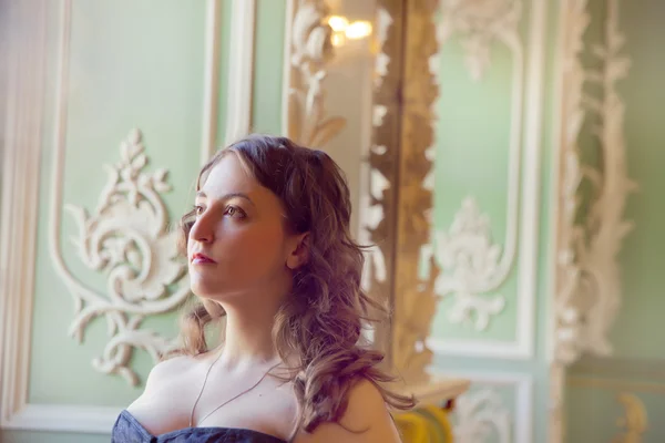 Krásná žena nosí korzet pózuje v paláci — Stock fotografie