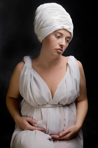 Mulher grávida vestida com um turbante e envolta em tecido branco . — Fotografia de Stock