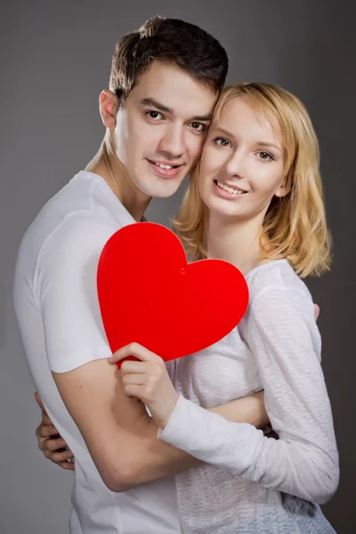 Jonge paar liefhebbers. Man presenteert rode roos voor dag van de Valentijnskaart. — Stockfoto