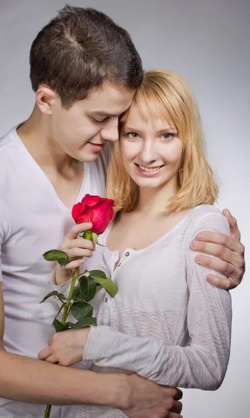 Young couple of lovers. Man presents red rose for Valentine day. Stock Photo