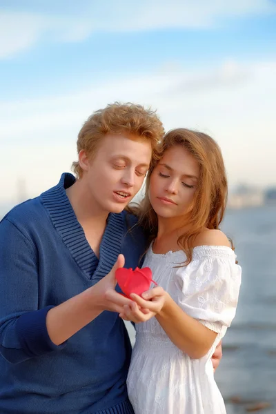 Dois amantes. Homem apresenta flor — Fotografia de Stock