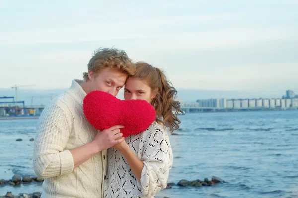Pareja de amantes sosteniendo fieltro corazón en San Valentín día / mar costo o — Foto de Stock