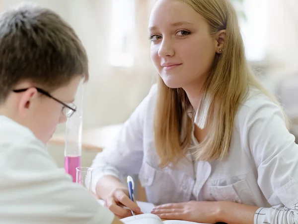 Schoolgirl  and boy  in science class . The first dating in the class — Stock Photo, Image