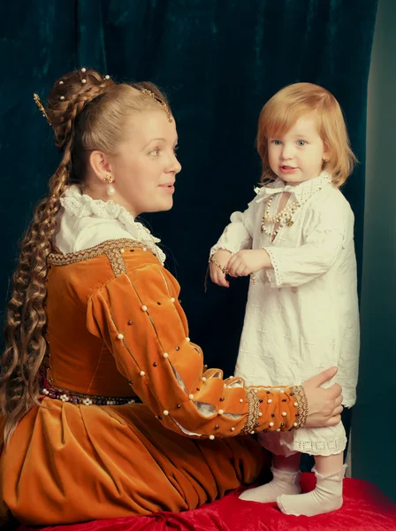 Vacker blond kvinna bär renässans klänning leker med Li Royaltyfria Stockfoton