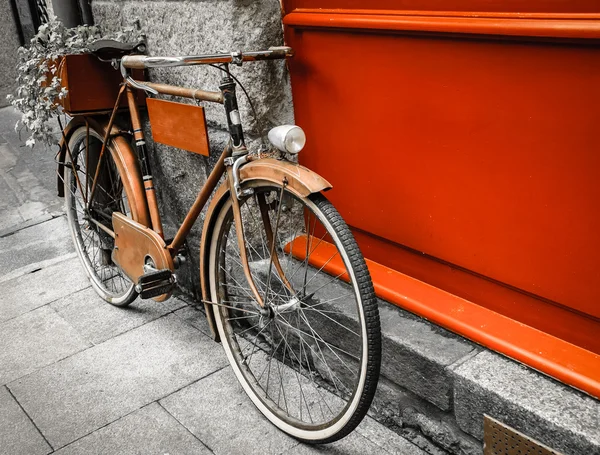 Vintage red bicycle leaning on red wooden board