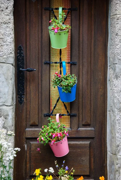 Puerta de casa de madera decorada con macetas de metal —  Fotos de Stock