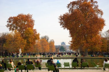 Parisians ve turistler Tuileries bahçesinde dinlenmek