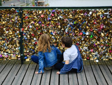 Erkek ve kız Paris'te aşk kilitleri köprüde.