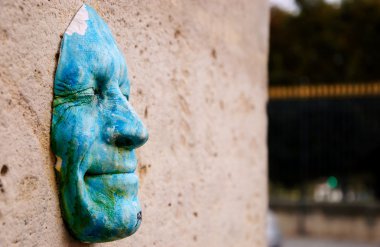 Mutlu yüz maskesi Tuileries Garden yakınındaki duvara.