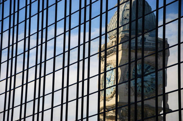 Reflection of clocktower of Gare de Lyon railway station in Paris in the skyscraper glass wall.