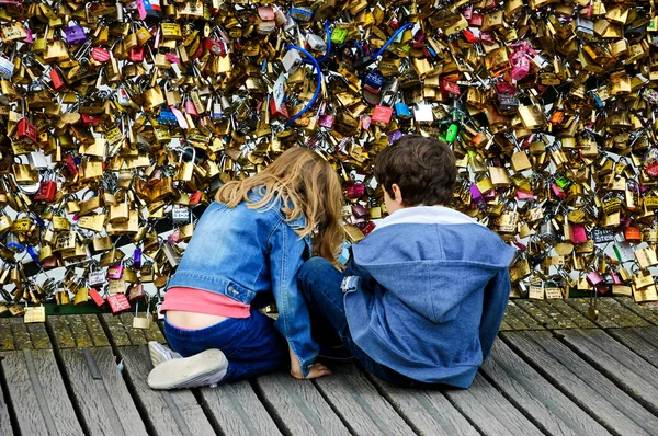 Boy and girl on Love locks bridge in Paris. — Stock Photo, Image