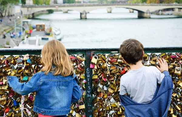 Boy and girl on Love locks bridge in Paris. — Stock Photo, Image