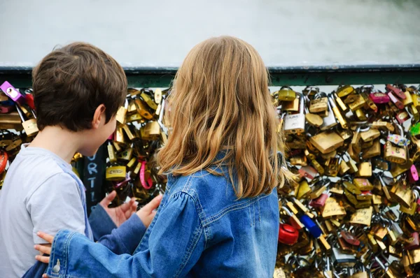 Boy and girl on Love locks bridge in Paris. — Stock Photo, Image