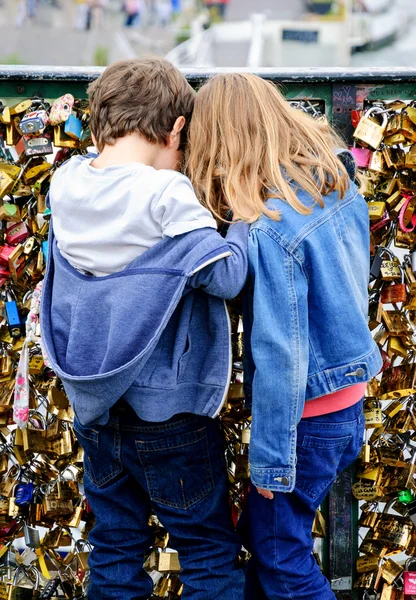 Boy and girl on Love locks bridge in Paris. — Stock Photo, Image