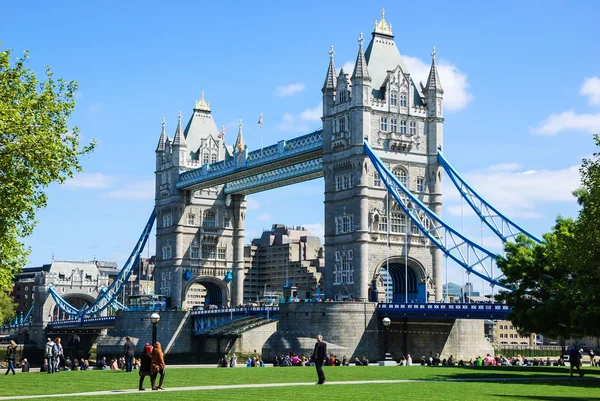 Tourists rest in park with a view on Tower bridge — Stock Photo, Image