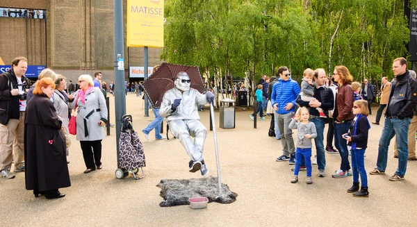 Floating man in silver costume sitting in the air — Stock Photo, Image