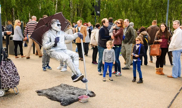 Floating man in silver costume sitting in the air — Stock Photo, Image