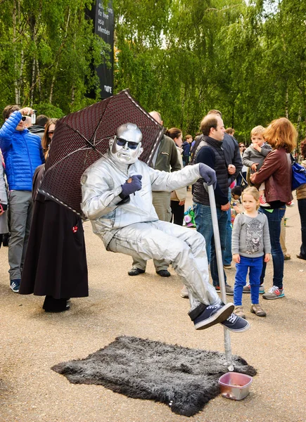 Floating man in silver costume sitting in the air — Stock Photo, Image