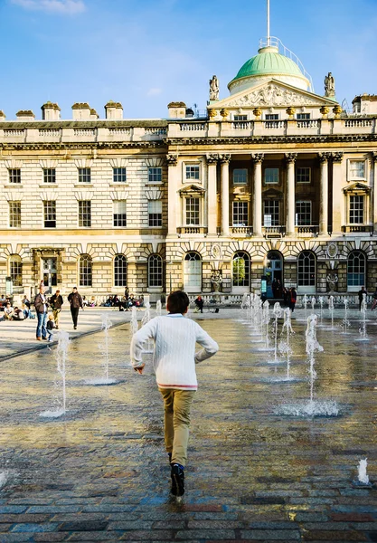 Rapaz a correr pela água na Somerset House . — Fotografia de Stock