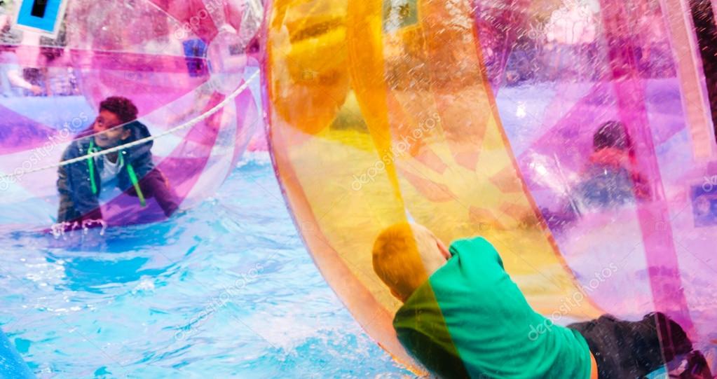 Kids zorb inside large balls during Canalway Cavalcade Stock