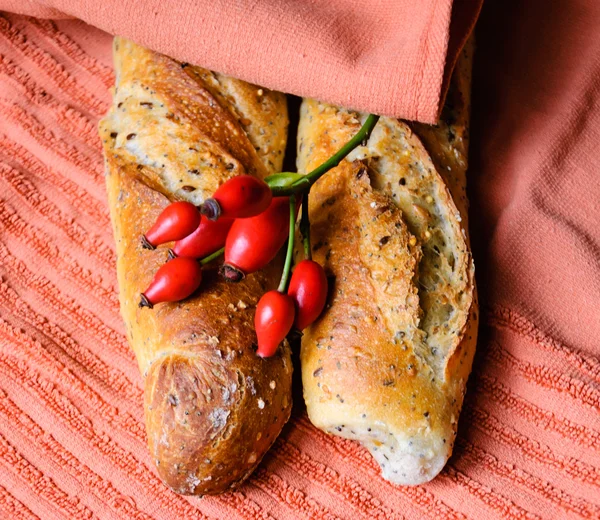 Panes multigrano recién horneados sobre una vieja toalla grumosa. Estilo rústico . — Foto de Stock