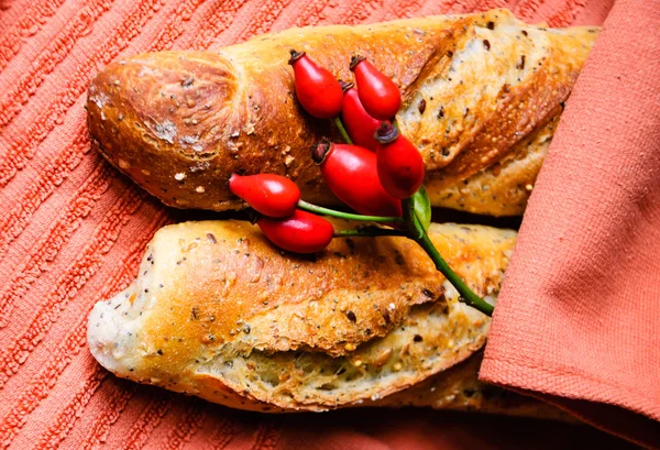 Panes multigrano recién horneados sobre una vieja toalla grumosa. Estilo rústico . — Foto de Stock