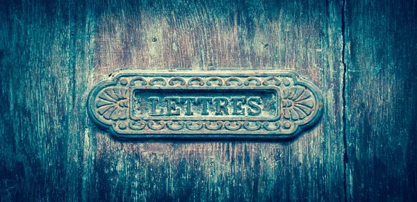 Ornate brass letterbox dengan tulisan LETTRES ("Surat" dalam bahasa Prancis). Tours, Perancis. Foto yang menua . — Stok Foto