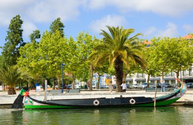 Aveiro, Portekiz - 27 Nisan 2015: Turistler Moliceiro tekneleri ile fotoğraf çektirin. Romantik, dini, tarihi veya mizahi sahneleri betimleyen bu geleneksel yarım ay şeklindeki tekneler.