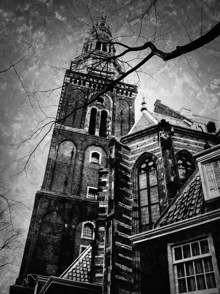 Oude Kerk (Iglesia Vieja) en Amsterdam (Países Bajos) vista a través de las ramas desnudas de los árboles. Foto retro envejecida con arañazos. Blanco y negro . —  Fotos de Stock