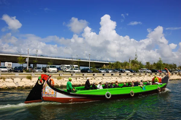 Aveiro, Portugal-april 27, 2015: Senior turister tar en kryssning i Moliceiro båtar. Dessa traditionella färgglada halvmånformade båtar som skildrar romantiska, religiösa historiska eller humoristiska scener. — Stockfoto