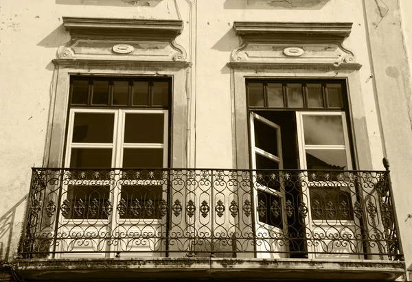 Balcony with wrought iron railing. Old typical house in Evora, Portugal. Historic Centre of Evora is a UNESCO World Heritage Site. Aged photo. Sepia. — Stock Photo, Image