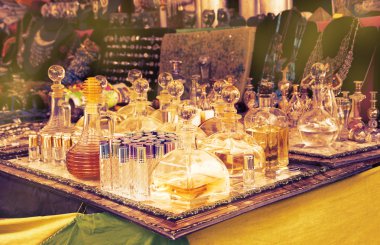 Vintage perfume bottles at flea market in Portugal. Toned photo with light glow.