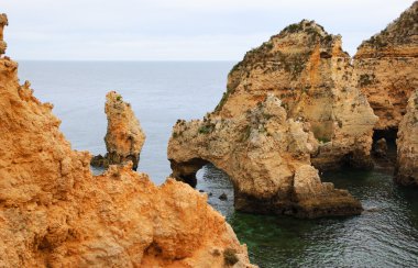 Taş kemer, mağaralar, kaya oluşumları Dona Ana Beach (Lagos, Algarve kıyısında, Portekiz) akşam ışık. 