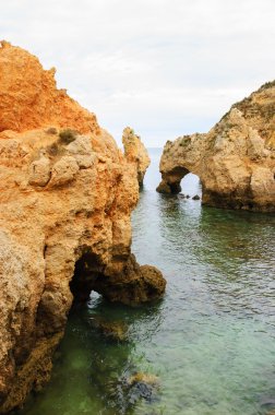 Taş kemer, mağaralar, kaya oluşumları Dona Ana Beach (Lagos, Algarve kıyısında, Portekiz) akşam ışık. 