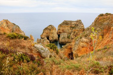 Akşam ışığında Dona Ana Plajı'nda (Lagos, Algarve sahili, Portekiz) taş kemerler, mağaralar ve kaya oluşumları. Yukarıdan bir görünüm.