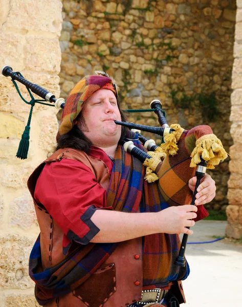 LAGOS, PORTUGAL - MAY 3, 2015: Bagpiper in traditional costume playing at local medieval fair. — Stock Photo, Image