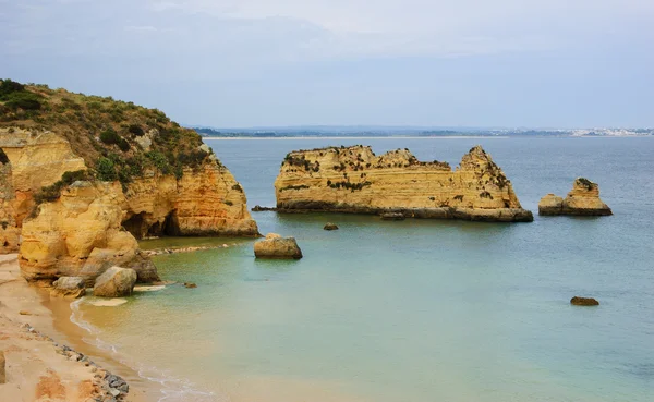 A kő boltozatok, barlangok, sziklaalakzatok: Dona Ana Beach (Lagos, Algarve part, Portugália) az esti fényben. — Stock Fotó