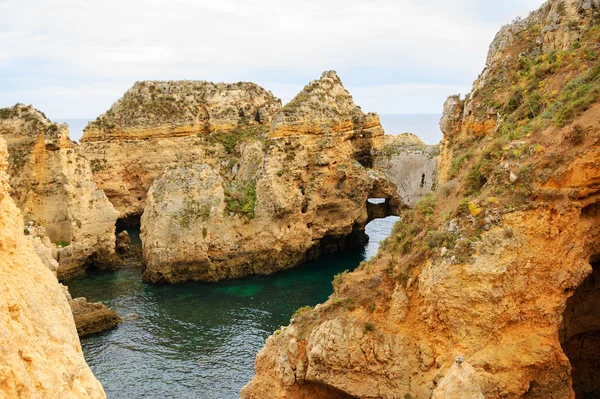 A kő boltozatok, barlangok, sziklaalakzatok: Dona Ana Beach (Lagos, Algarve part, Portugália) az esti fényben. — Stock Fotó