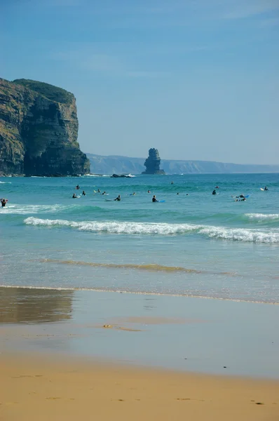 Praia na região algarvia de Portugal. Pessoas nadando e surfando. Foto envelhecida. Preto e branco . — Fotografia de Stock