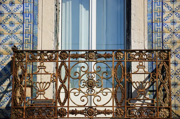 Rusty forjamento varanda e azulejos (azulejos) parede cerâmica. Pormenores arquitectónicos do típico edifício antigo no centro de Lisboa (Portugal ). — Fotografia de Stock