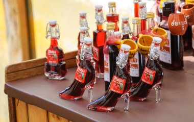 OBIDOS, PORTUGAL - APRIL 30, 2015: Traditional Ginja (sour cherry liqueur ) in chocolate cups is proposed for tourists. This natural handmade liqueur is  Obidos'  specialty. clipart