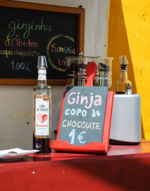 Obidos, Portekiz - 30 Nisan 2015: Çikolata bardaklarında geleneksel Ginja (vişne likörü) turistler için önerilmektedir. Bu doğal el yapımı likörü Obidos'un uzmanlık alanıdır..