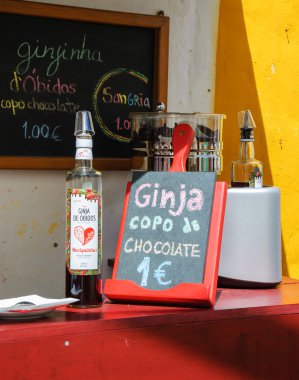 Obidos, Portekiz - 30 Nisan 2015: Çikolata bardaklarında geleneksel Ginja (vişne likörü) turistler için önerilmektedir. Bu doğal el yapımı likörü Obidos'un uzmanlık alanıdır..