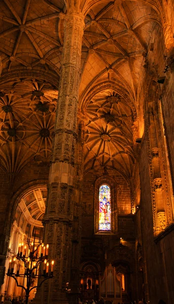 LISBOA, PORTUGAL - 22 de abril de 2015: Colunas, velas e órgãos na Igreja do Mosteiro dos Jerônimos. Este mosteiro é um dos exemplos mais proeminentes do estilo manuelino gótico português . — Fotografia de Stock