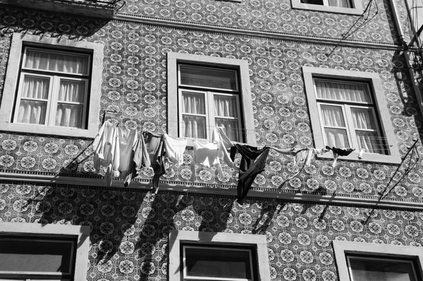 Típico edificio antiguo en el centro de Lisboa (Portugal) con baldosas cerámicas (azulejos) y la ropa interior colgando para secar al sol. Foto envejecida. Blanco y negro . —  Fotos de Stock