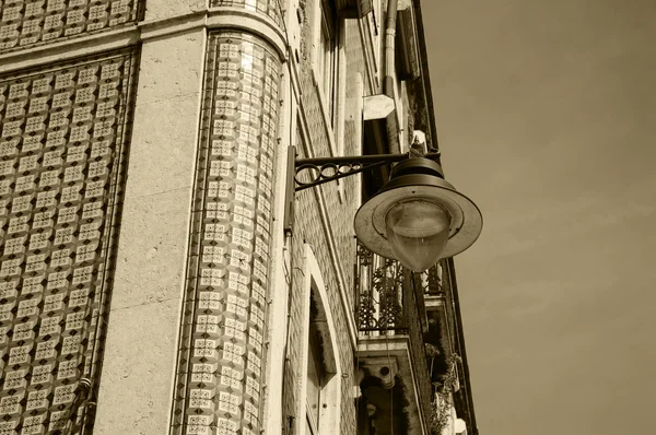 Roh typické staré budově v centru Lisabonu (Portugalsko). Barevné keramické dlaždice (azulejos) s geometrickým vzorem a závěsná Lucerna. Věku fotografie. Sépie. — Stock fotografie