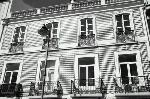 Typisches altes gebäude im zentrum von Lissabon (portugal). Keramikplatten (Azulejos) mit Rautenmuster, Balkone mit schmiedeeisernem Geländer und Balustrade auf dem Dach. Altersfoto. schwarz-weiß. — Stockfoto