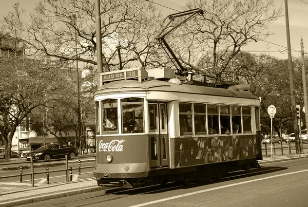 LISBOA, PORTUGAL - 22 DE ABRIL DE 2015: Antiguo tranvía con publicidad de Coca Cola circulando por el centro histórico de Lisboa. La compañía Coca-Cola fue fundada en el siglo XIX . — Foto de Stock